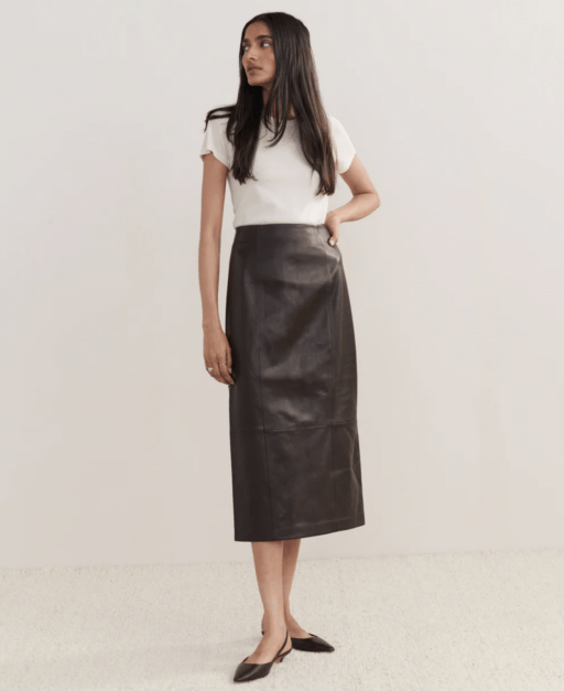 woman with long dark hair modeling brown leather skirt, white t-shirt, and black flats